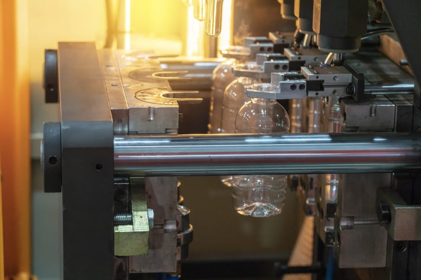 Plastic bottles being blow molded and formed